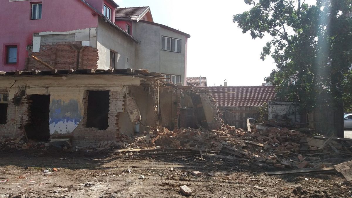 Durante: la misma casa parcialmente demolida, ladrillo y madera separados en montones